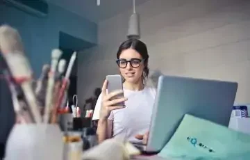 woman in white shirt using smartphone